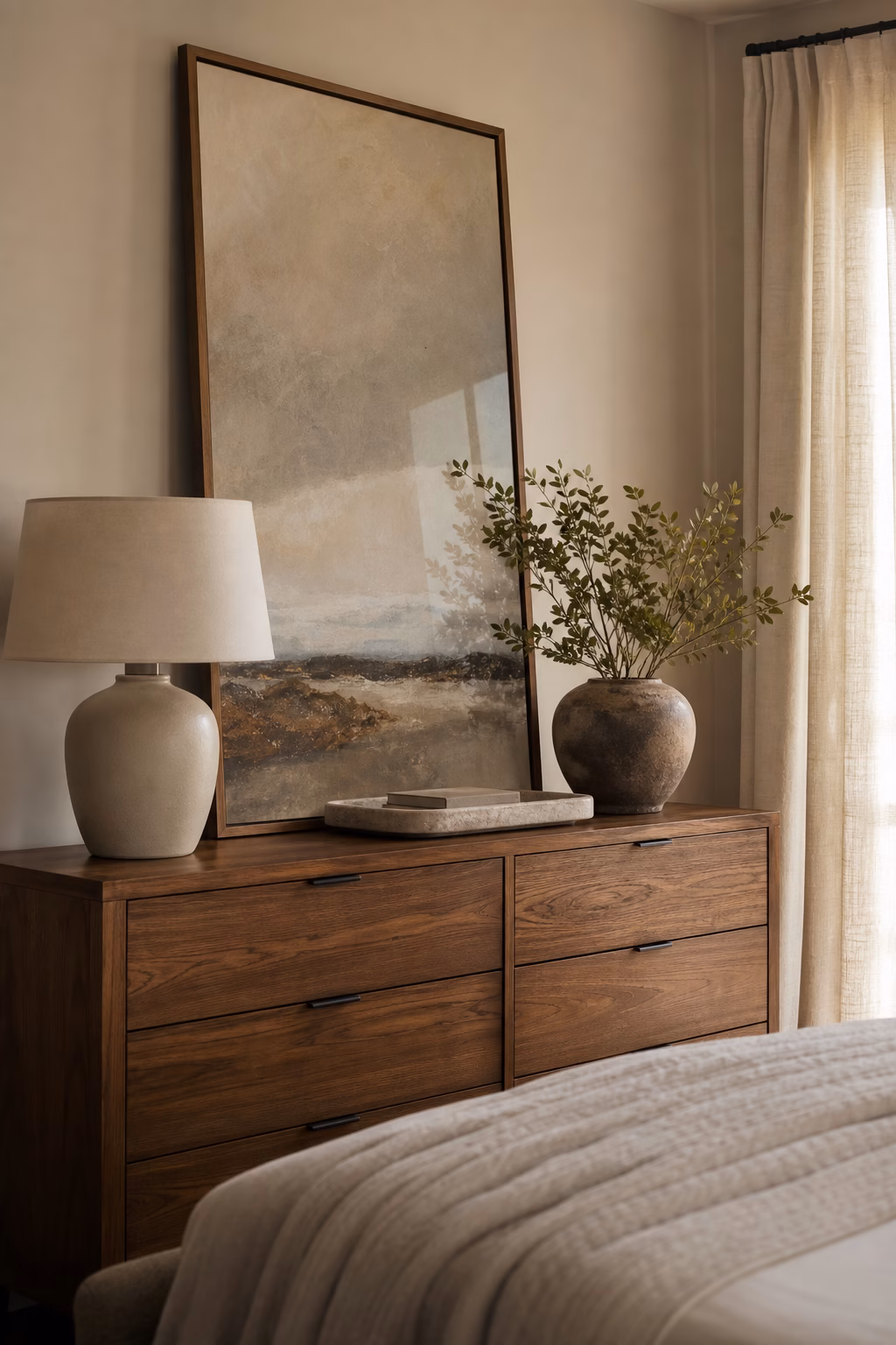 Large leaning framed artwork styling an elegant bedroom dresser