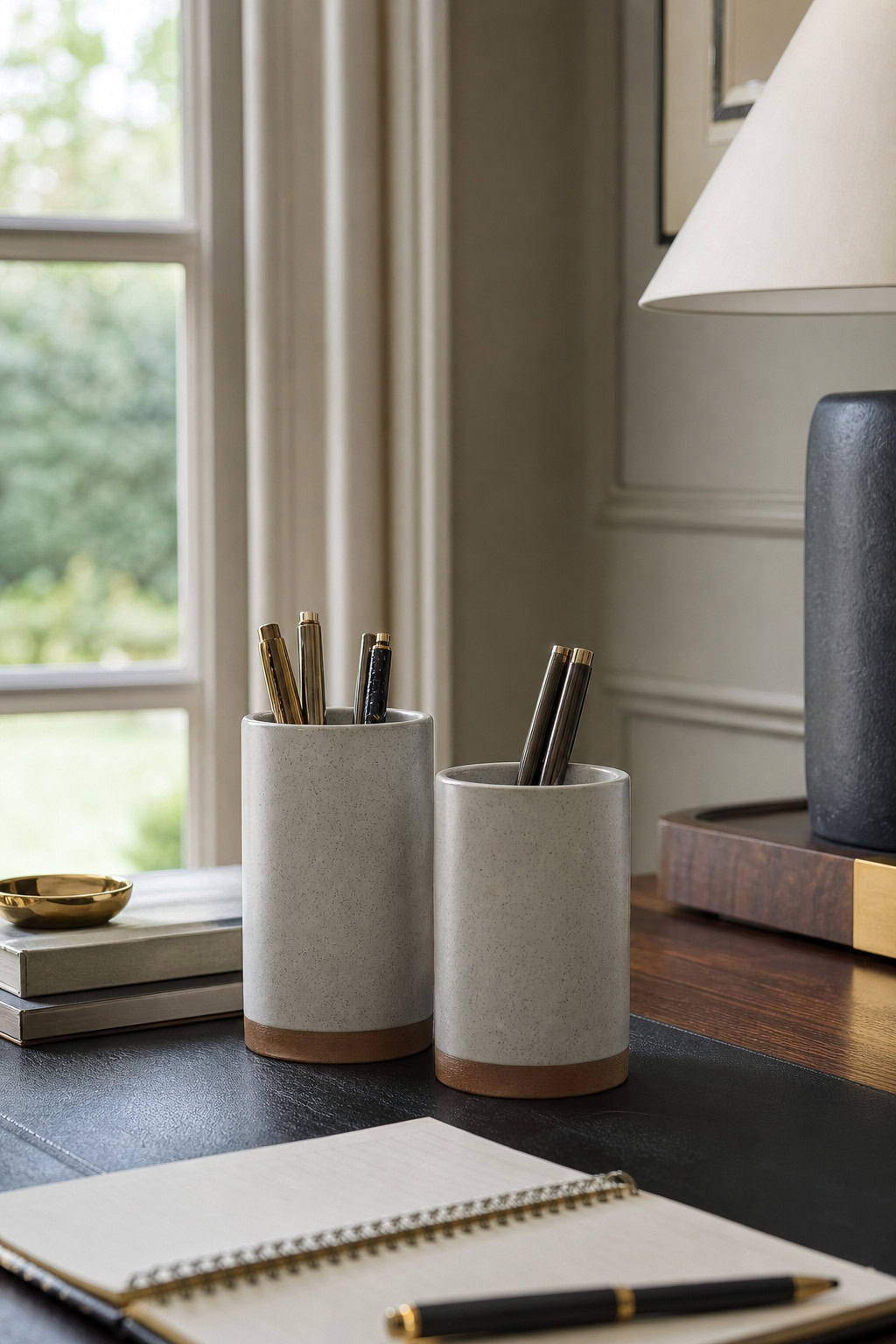 Matching ceramic desk cups holding a restrained set of writing tools