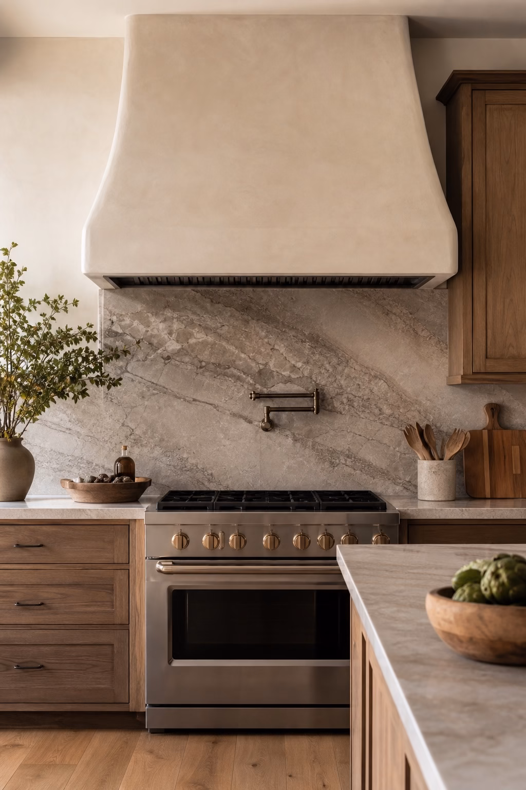 Kitchen range wall with plaster hood, stone slab backsplash, wood cabinets, and edited accessories