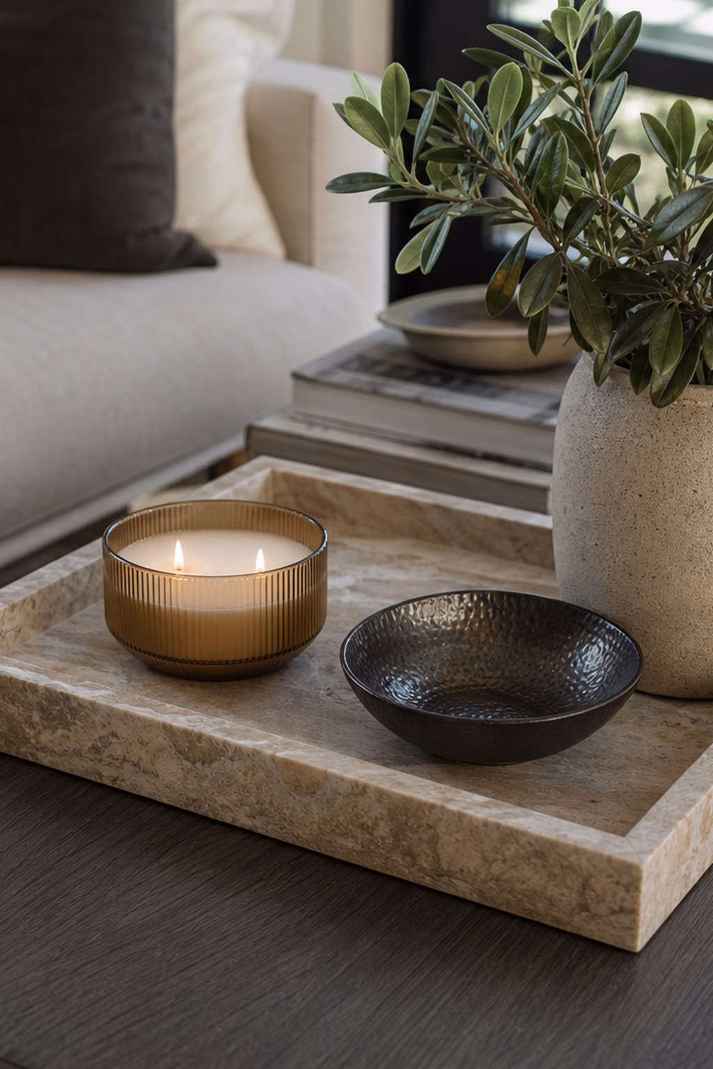 Stone decorative tray organizing a coffee table with candle and bowl.