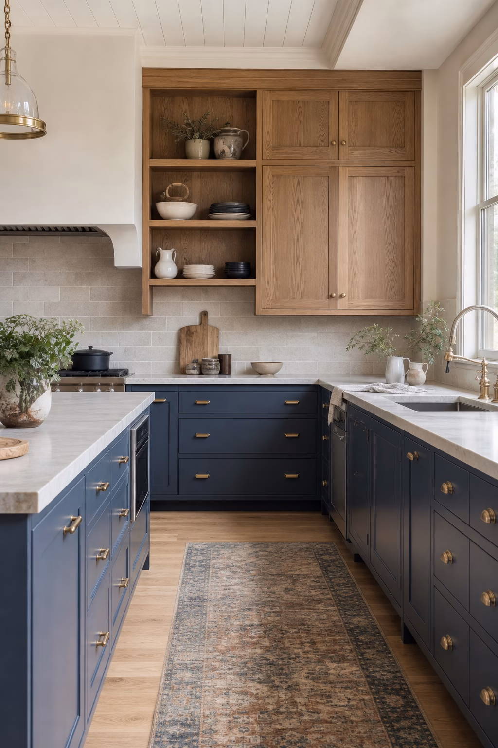 Open kitchen with denim blue cabinets, warm oak storage, and simple stone counters.