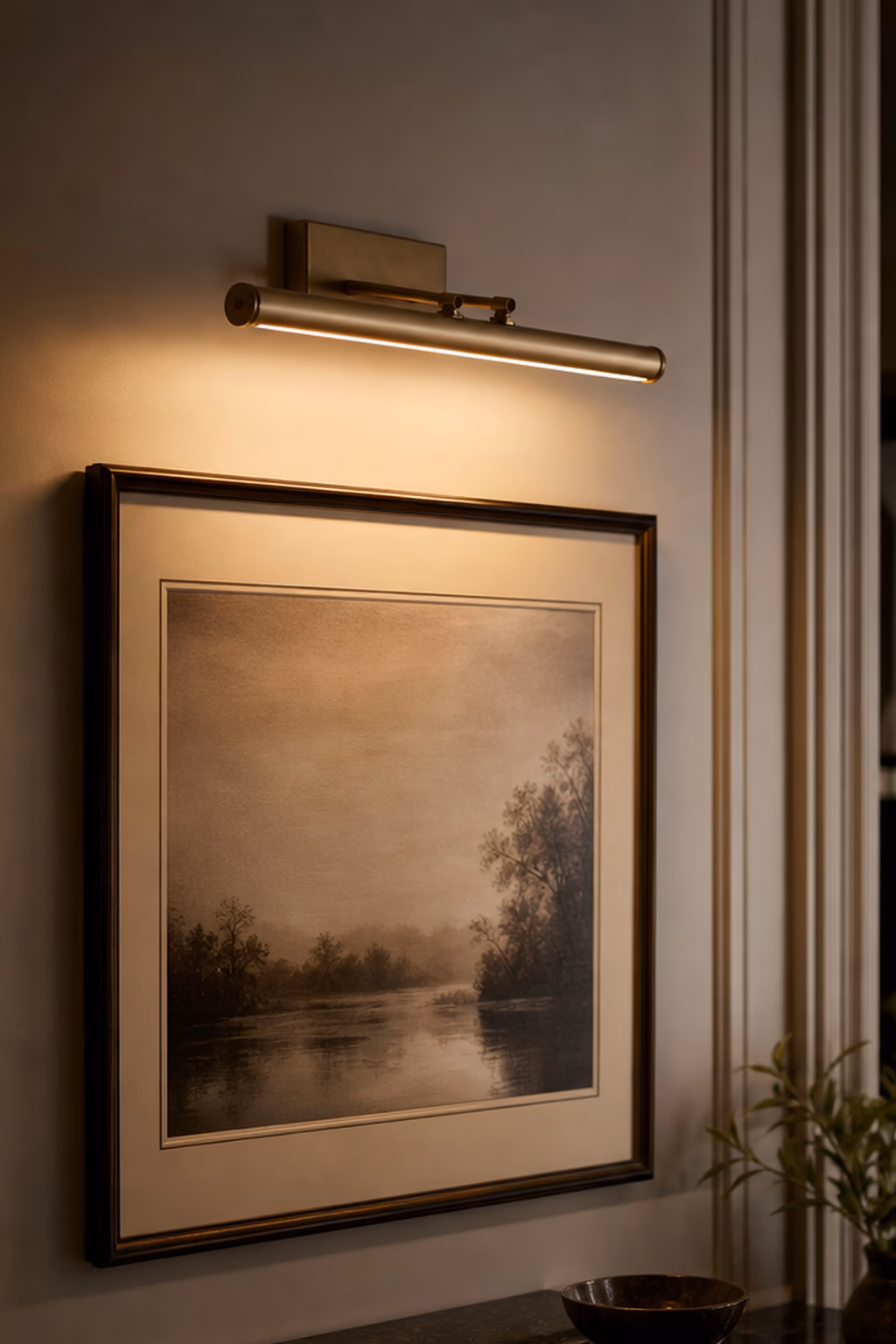 Battery picture light casting warm light over framed wall art.