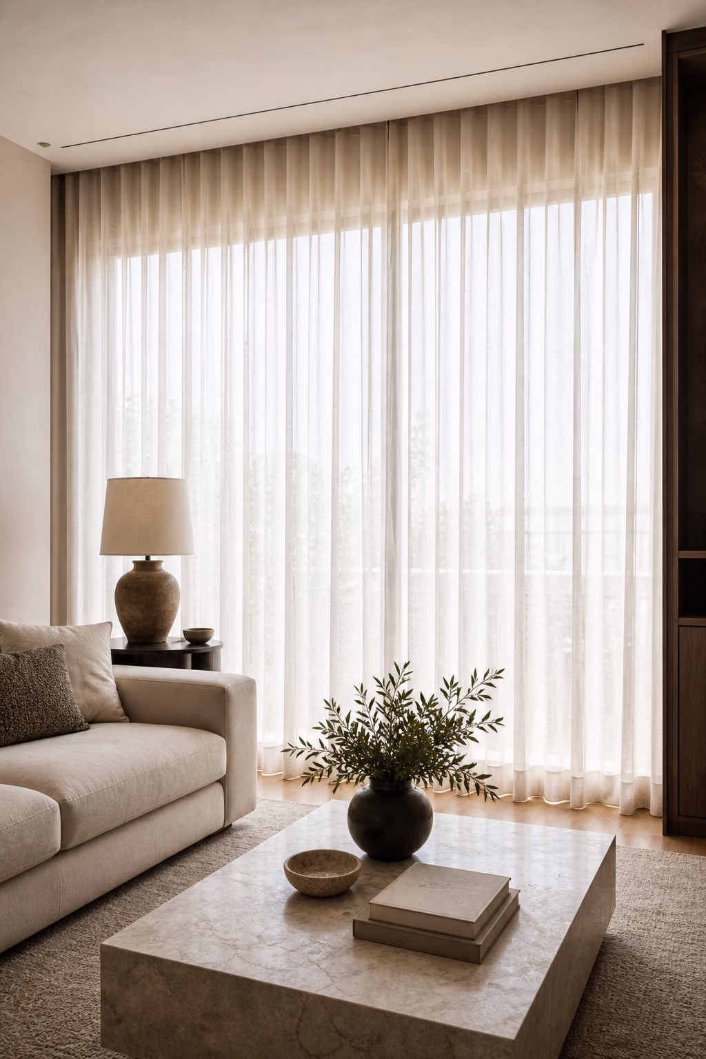Wall to wall ceiling track curtains creating softness in an apartment living room