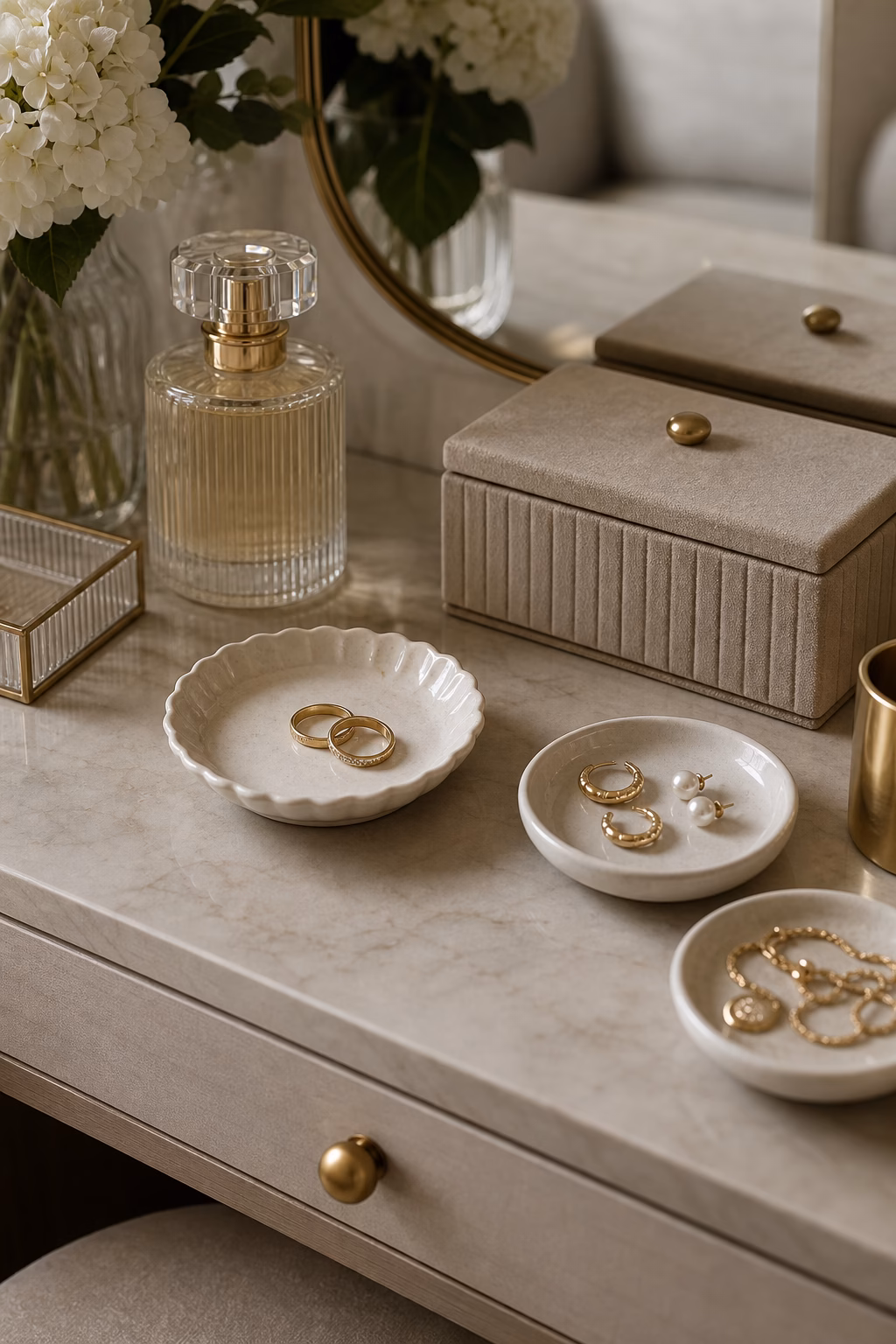 Small ceramic jewelry dishes arranged on an elegant dressing table.