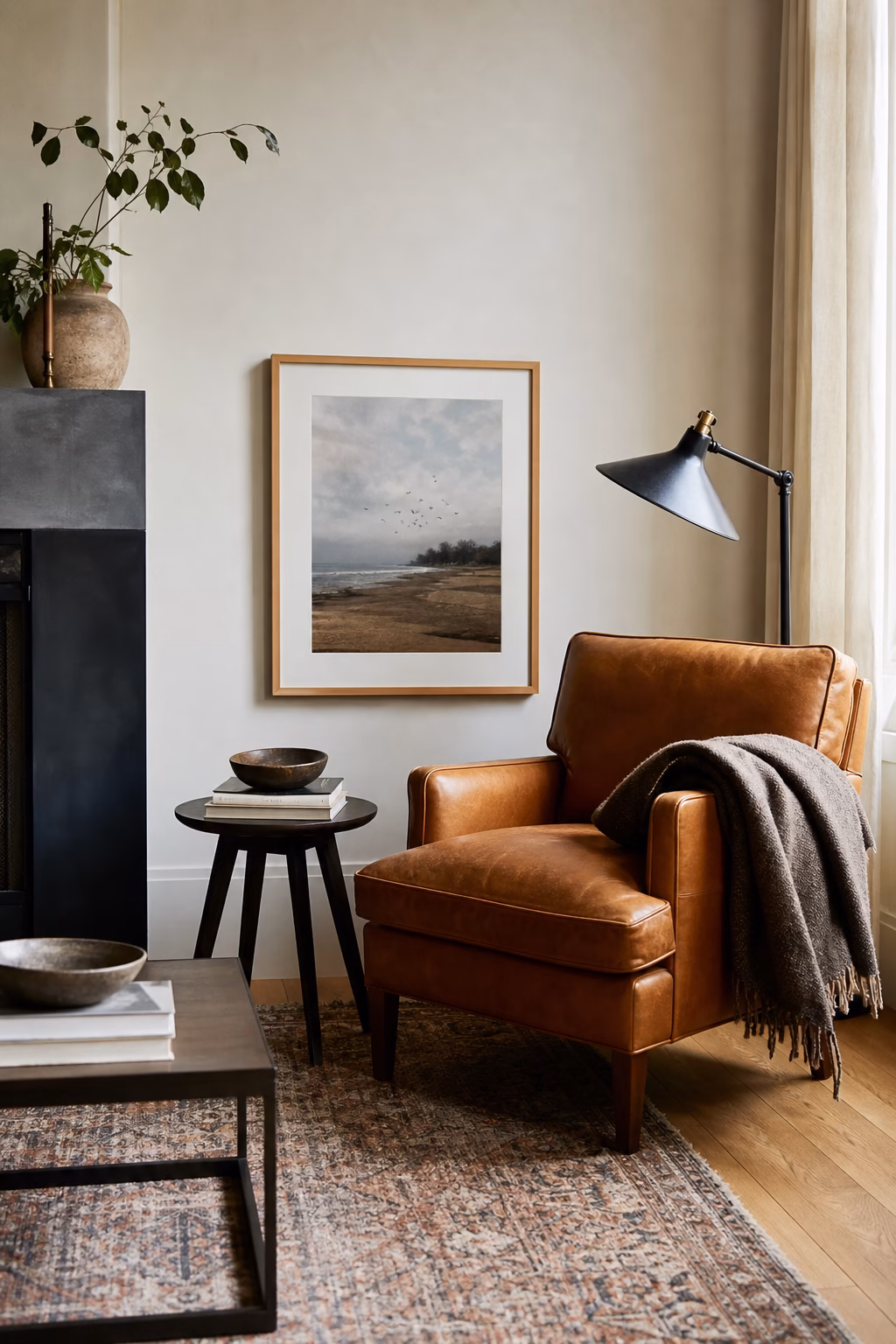 Artwork hung low beside a living room reading chair