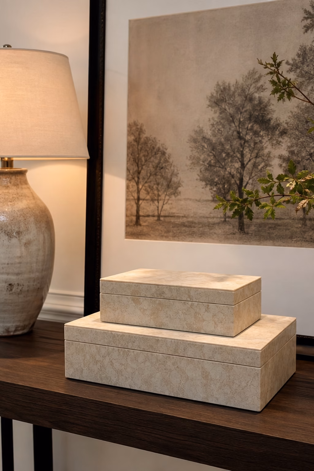 Lidded decorative boxes hiding clutter on a styled console table.