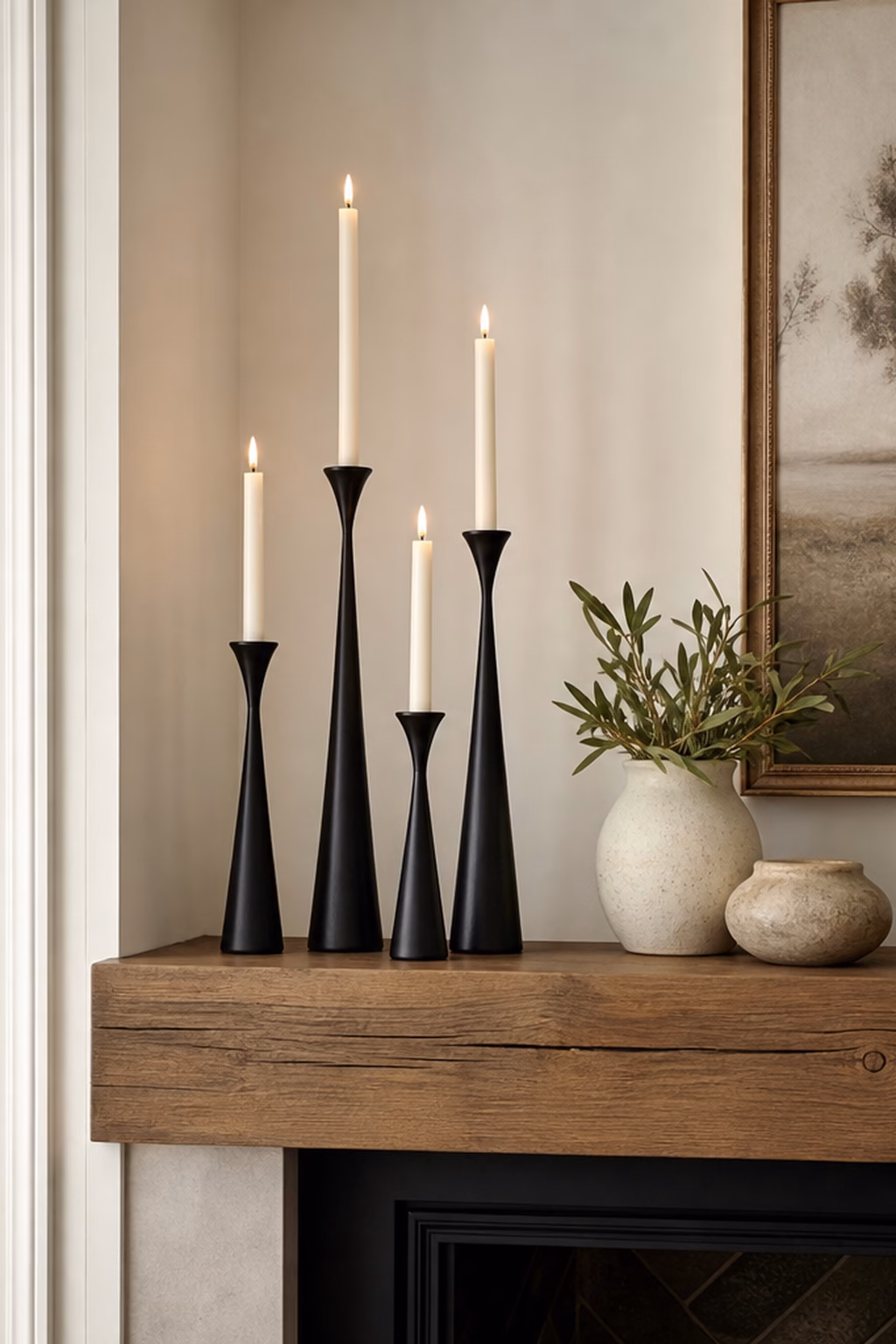 Matte black taper candle holders styled on a warm modern mantel.