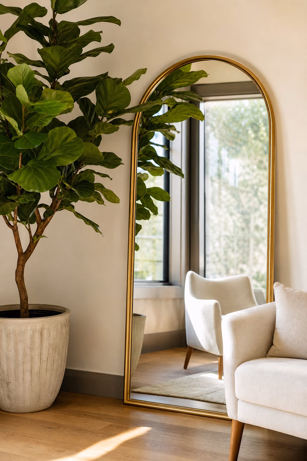 Arched gold mirror styled with a tall indoor plant