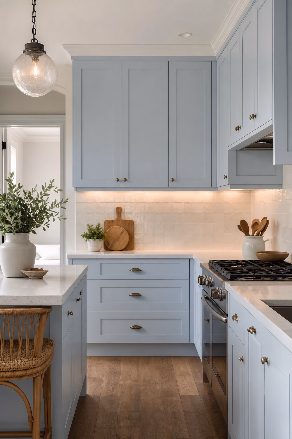 Small pale blue kitchen with light counters and warm wood accents.
