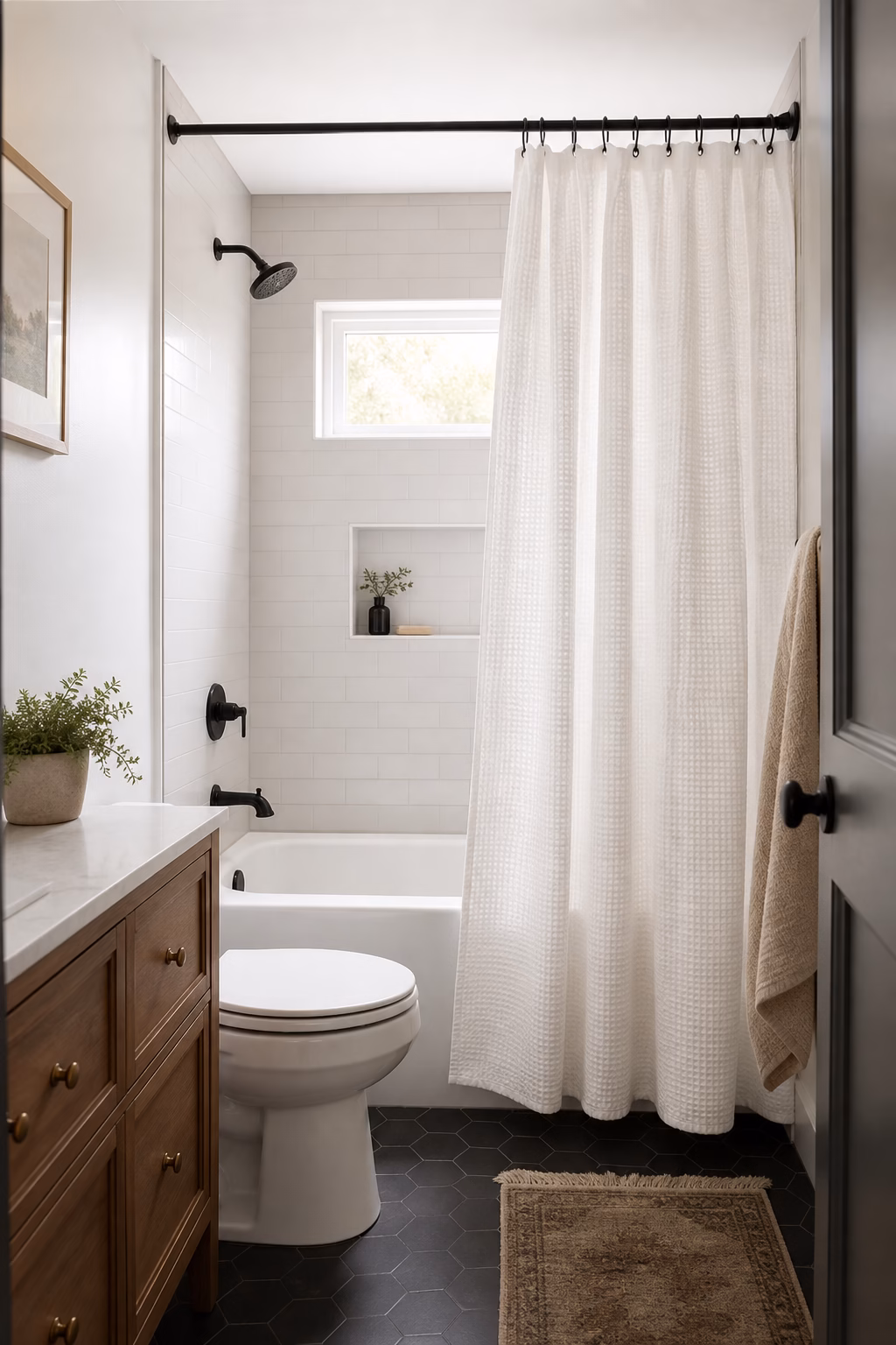 Small tub-shower bathroom with high black rod, white waffle curtain, clean liner, and neutral walls
