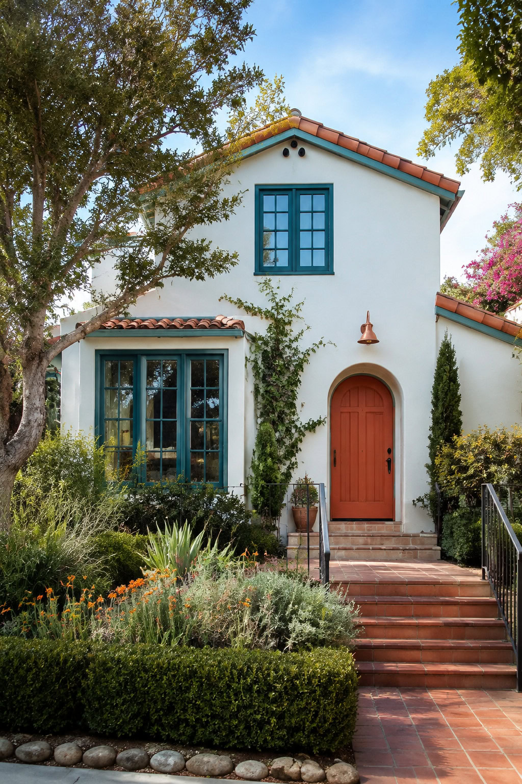 White house exterior with vivid teal trim and a terracotta door