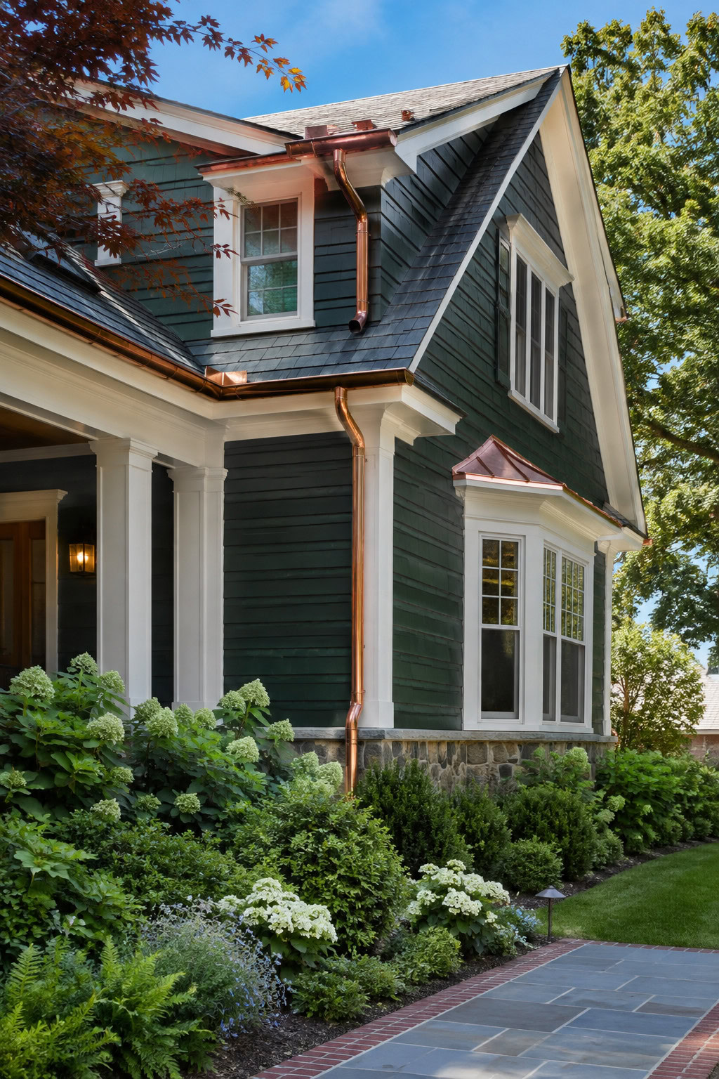 Stylish copper gutters on a deep green house exterior