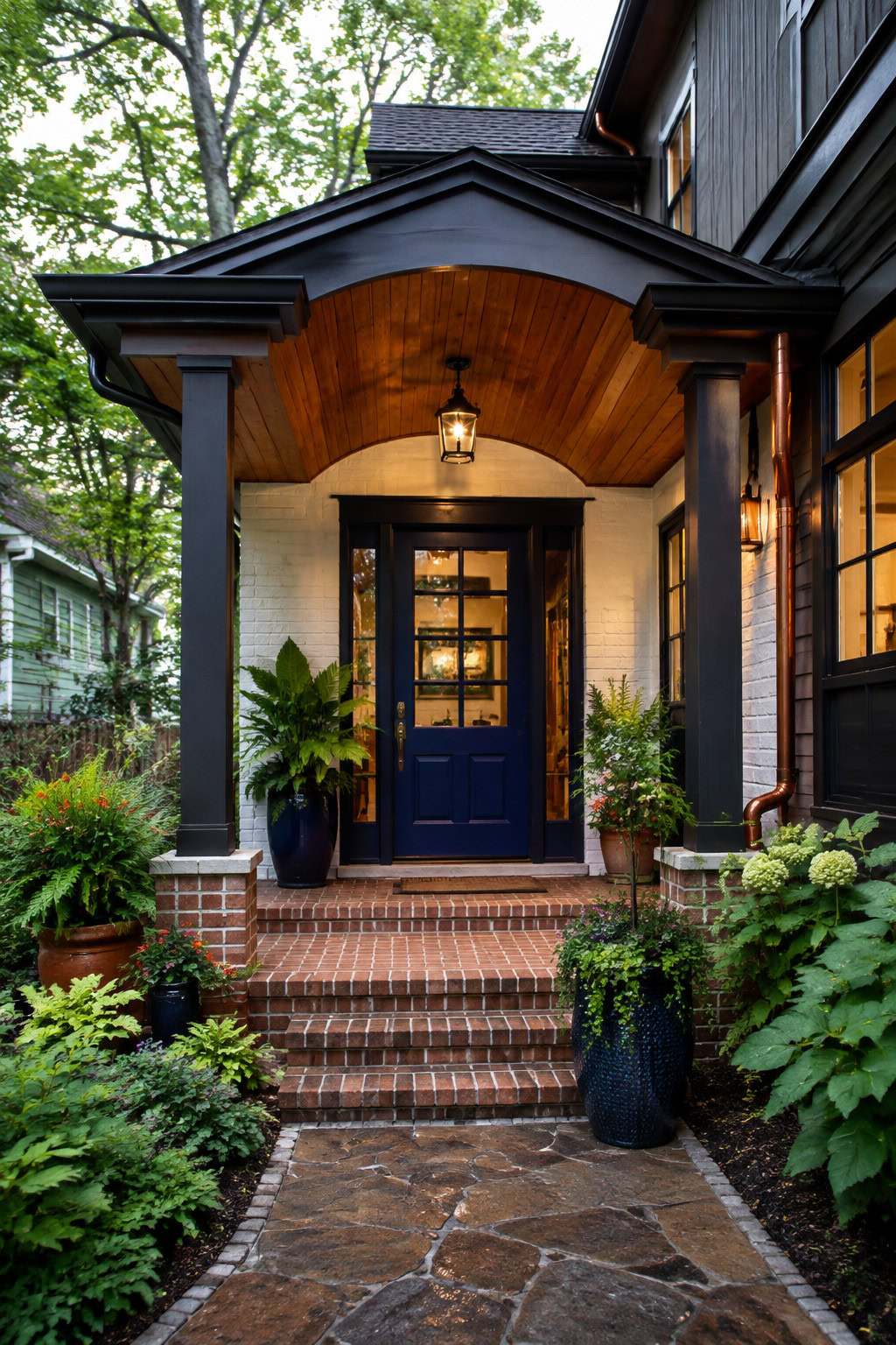 Enhanced entryway with cobalt door, brick steps, and planters